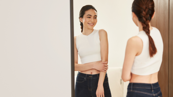 smiling woman in front of a mirror